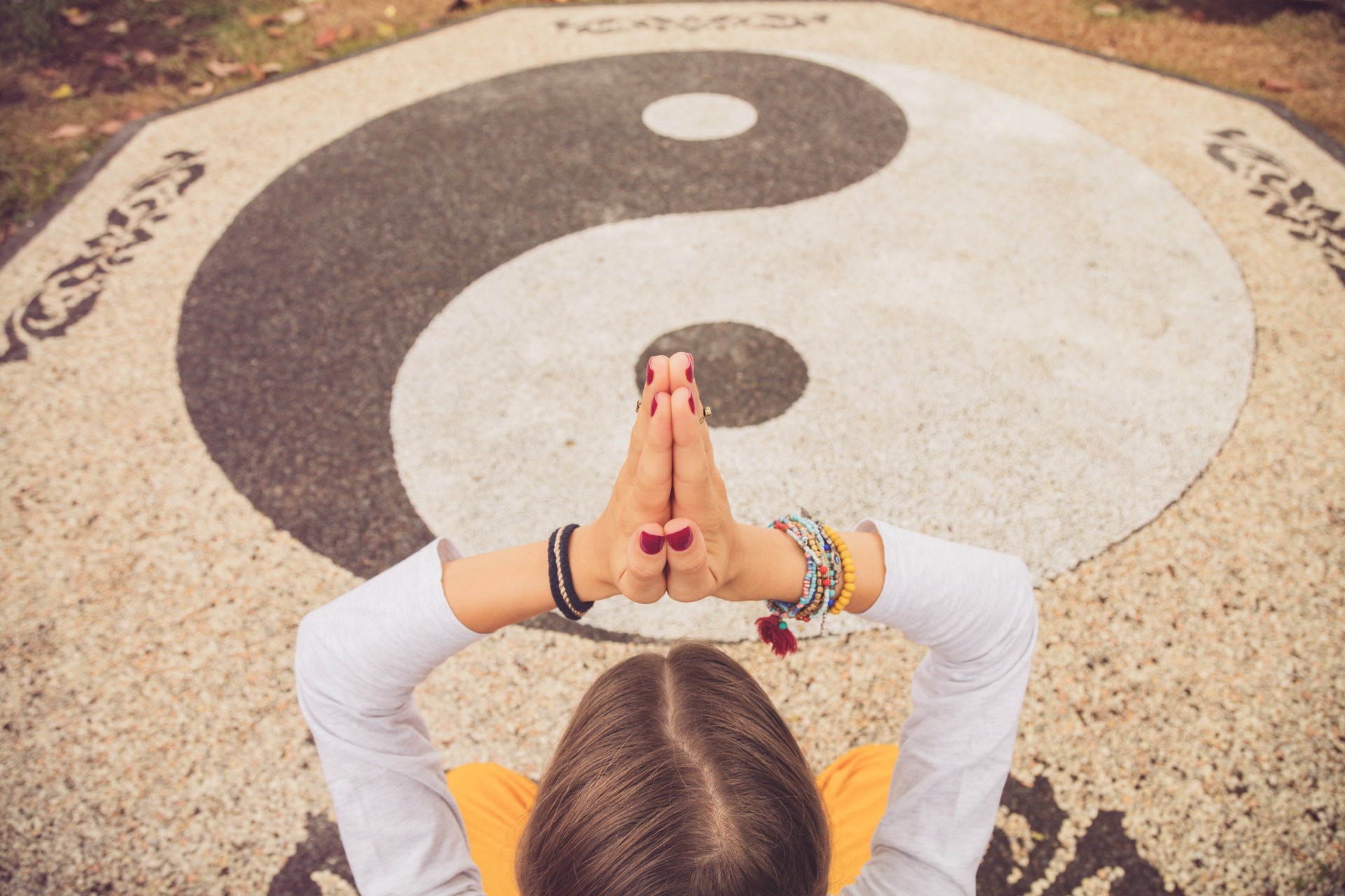 Young woman practicing yoga - meditation on the yin yang sign.